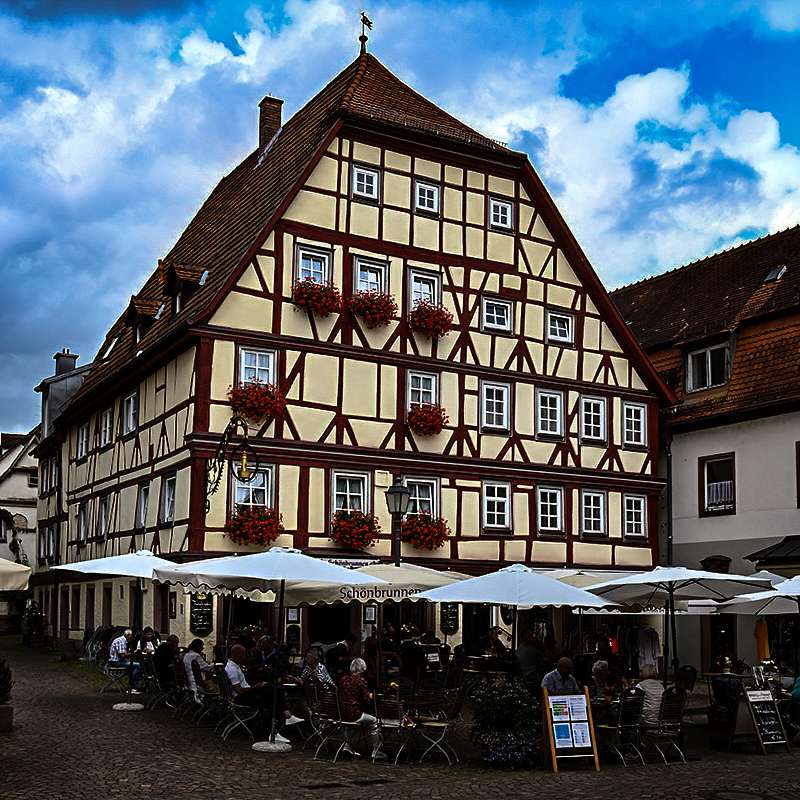 Gasthaus, Gäste unter Sonnenschirmen | © Bert Schwarz 2025